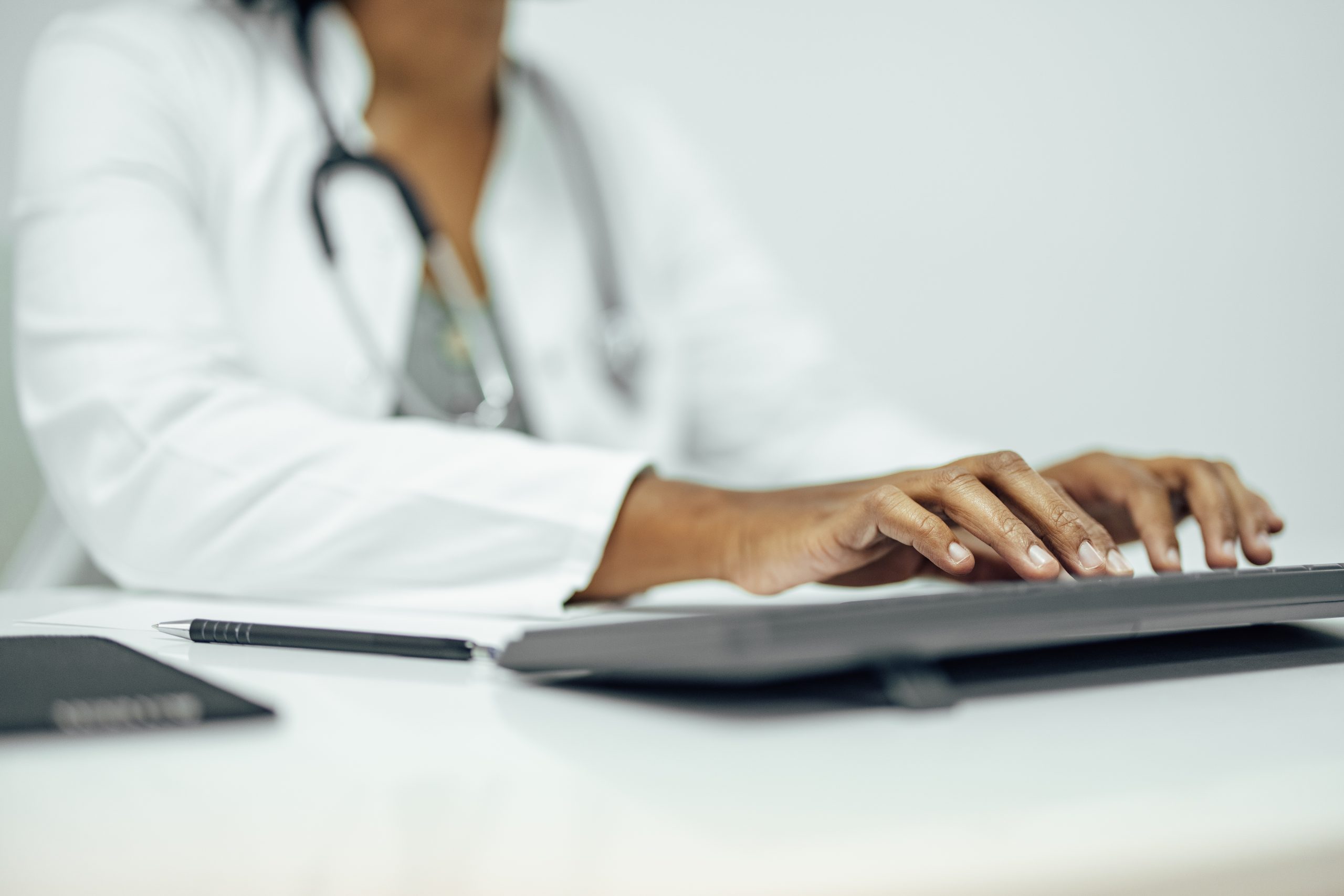 close up of a doctor typing report on computer utc